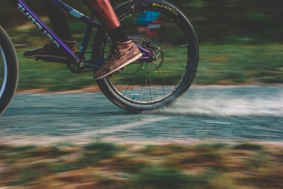 Close-up of a mountain biker speeding on a dusty trail, showcasing motion and excitement.