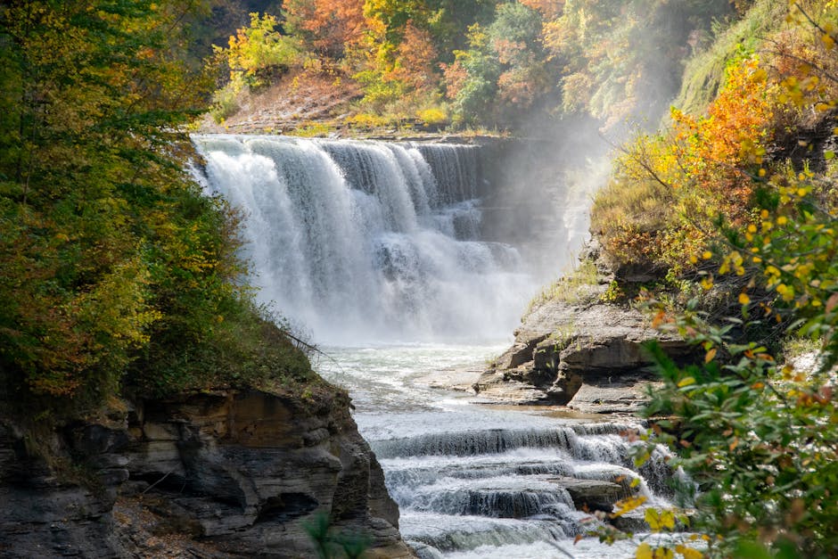 A stunning autumn waterfall cascading through vibrant fall foliage in Letchworth State Park, NY.