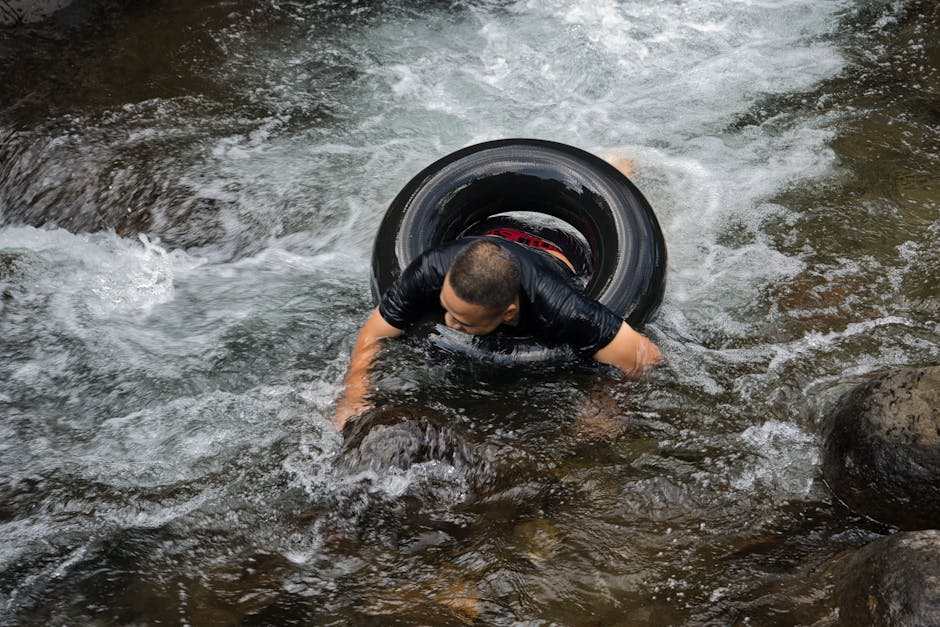 An adult man enjoys tubing down a rocky river, embracing outdoor adventure and nature.