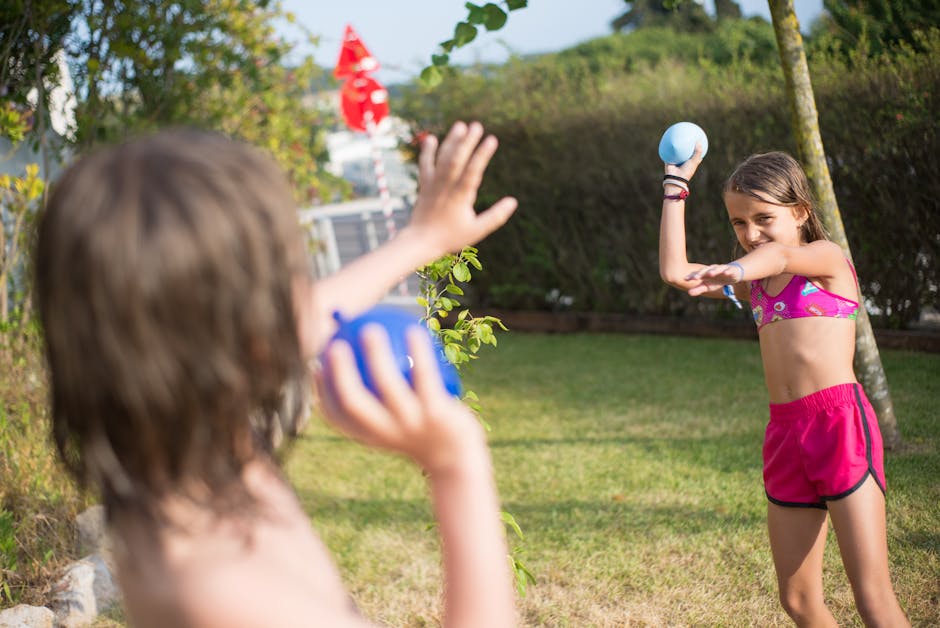 Children engage in a fun water balloon fight during a sunny day outdoors.
