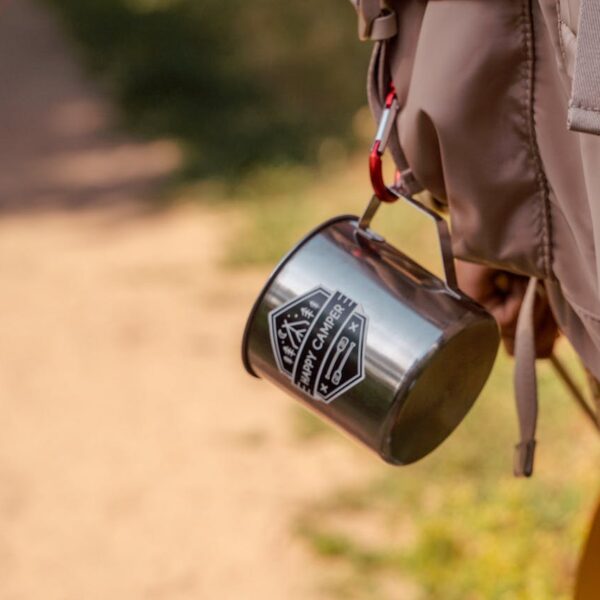 Hiking cup secured to the outside of a backpack with a carabiner, ready for the trail